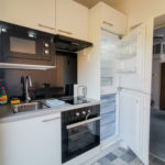 Full kitchen with oven, hob, microwave, sink & cooking utensils
